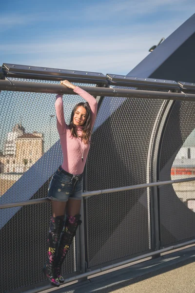 Hermosa joven morena posando en un puente — Foto de Stock