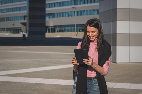 Krásná mladá brunetka pracuje na její tablet — Stock fotografie