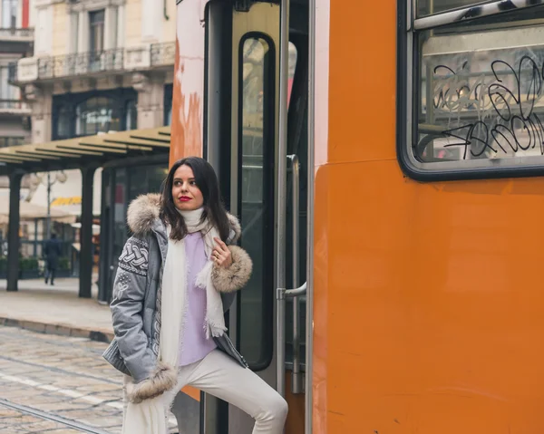 Beautiful young brunette taking a tram — Stock Photo, Image