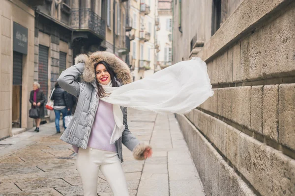 Krásná mladá brunetka pózuje v ulicích města — Stock fotografie