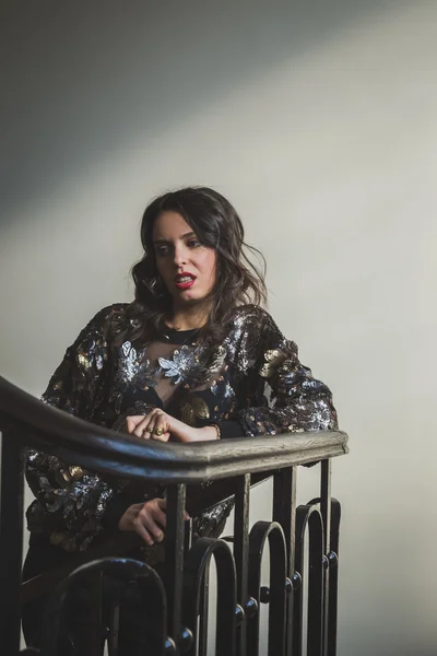 Portrait of a beautiful young brunette posing on the stairs — Stock Photo, Image