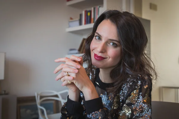 Portret van een mooie jonge brunette in de woonkamer — Stockfoto