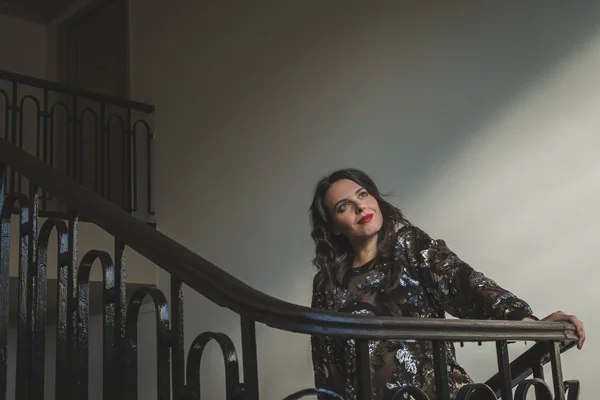 Portrait of a beautiful young brunette posing on the stairs — Stock Photo, Image