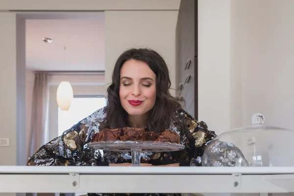 Vacker ung brunett poserar med brownies — Stockfoto