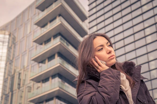 Krásná mladá dívka mluví telefonu v ulicích města — Stock fotografie