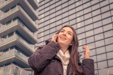 Şehir sokaklarında telefonda konuşurken genç güzel kız