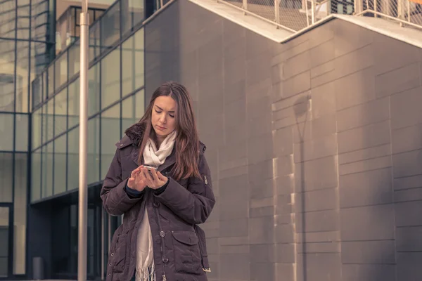 Joven hermosa chica mensajes de texto en las calles de la ciudad — Foto de Stock