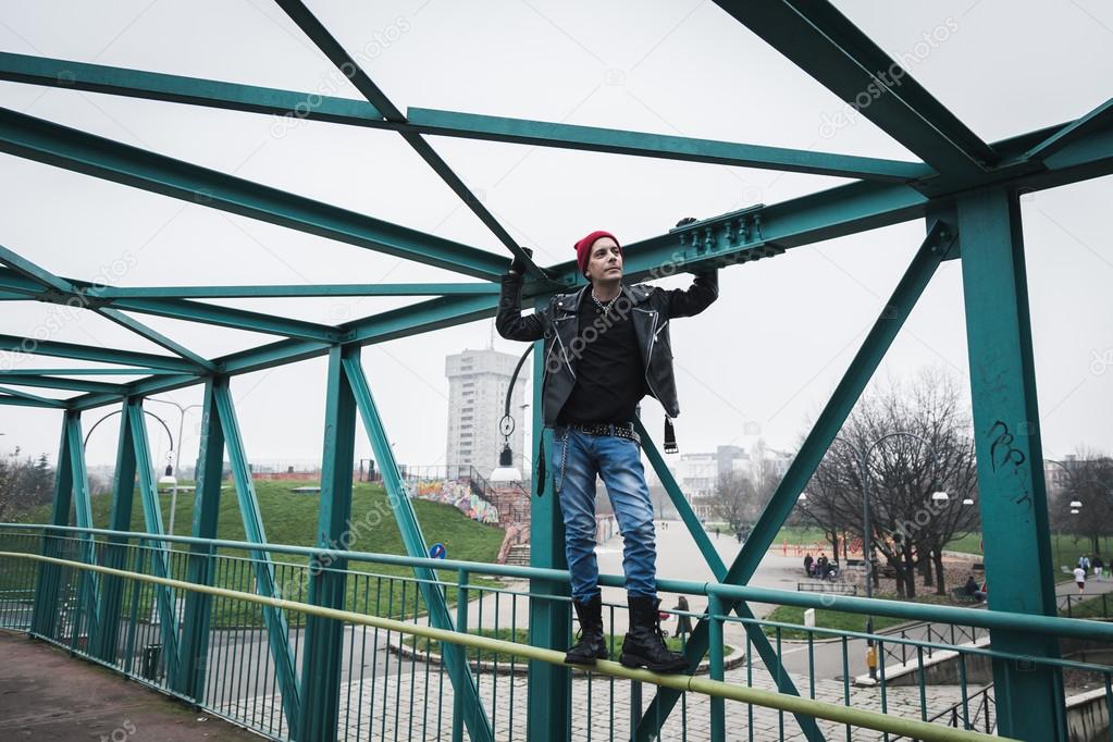 Punk guy standing on a bridge