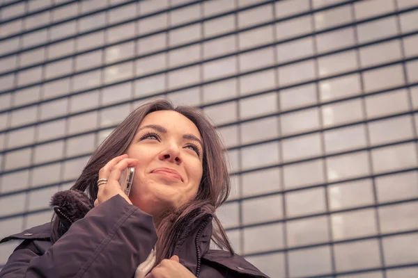 Jeune belle fille parlant au téléphone dans les rues de la ville — Photo