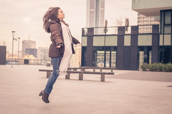 Ung vacker flicka hoppande på stadens gator — Stockfoto