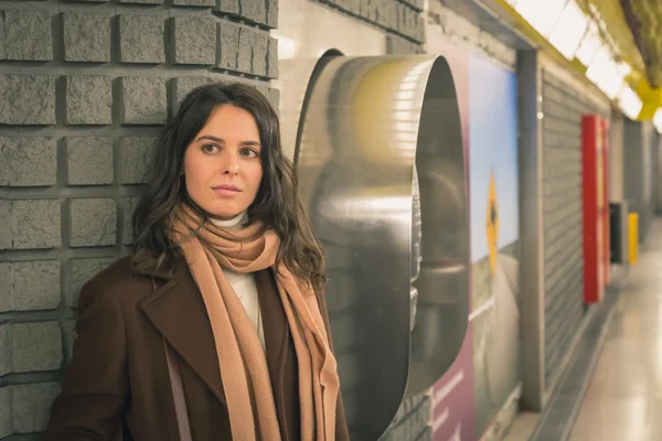 Schöne junge Frau posiert in einer Metrostation — Stockfoto