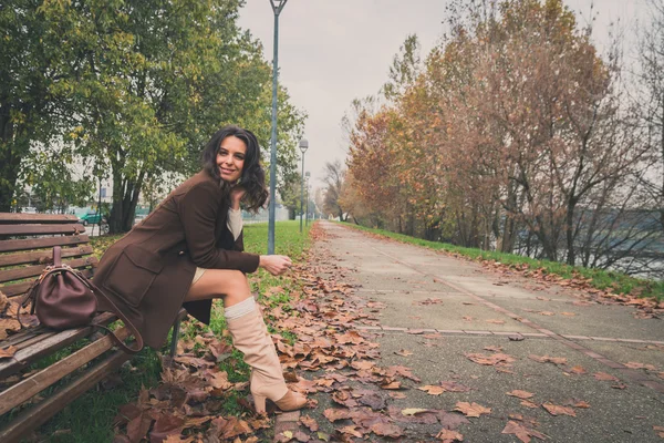 Beautiful young woman posing in a city park — Stock Photo, Image