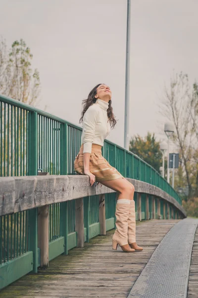 Beautiful young woman posing on a bridge — Stock Photo, Image