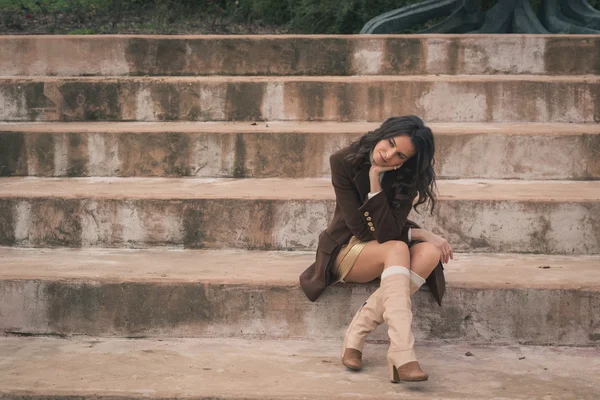Красива молода жінка сидить на бетонних сходах — стокове фото