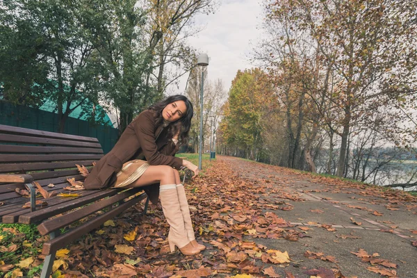 Beautiful young woman posing in a city park — Stock Photo, Image