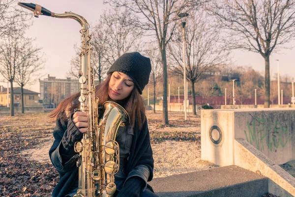 Beautiful young woman with her saxophone — Stock Photo, Image