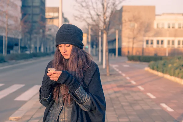 Vacker ung kvinna textning på stadens gator — Stockfoto