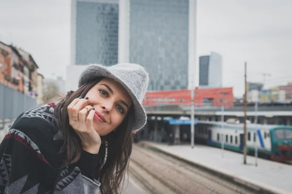 Krásná mladá brunetka pózuje v ulicích města — Stock fotografie