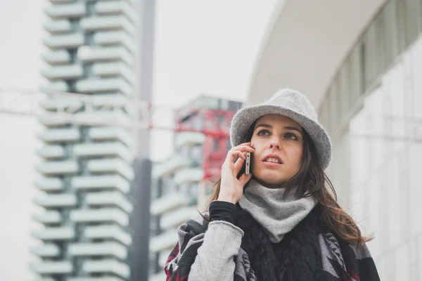 Piękna młoda brunetka rozmowy na telefon na ulicach miasta — Zdjęcie stockowe