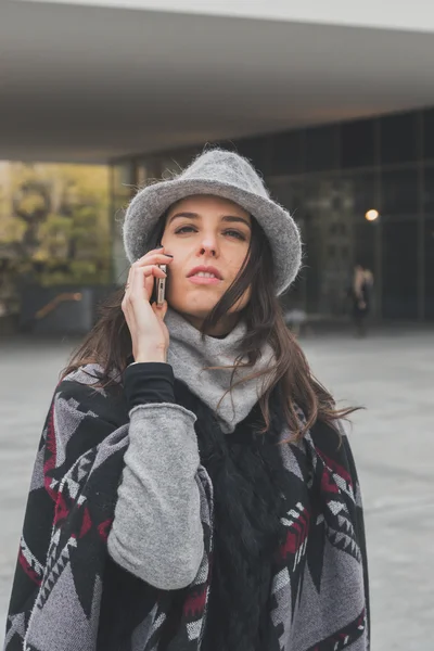 Mooie jonge brunette praten over telefoon in de straten van de stad — Stockfoto