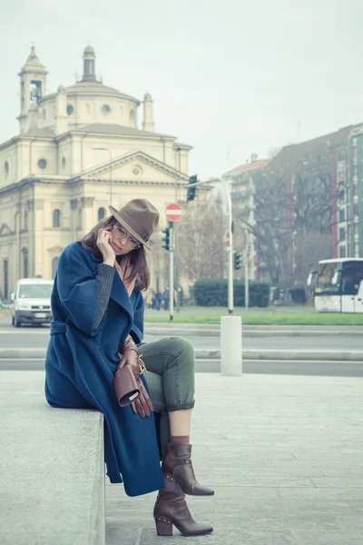 Beautiful young brunette talking on phone in the city streets — Stock Photo, Image