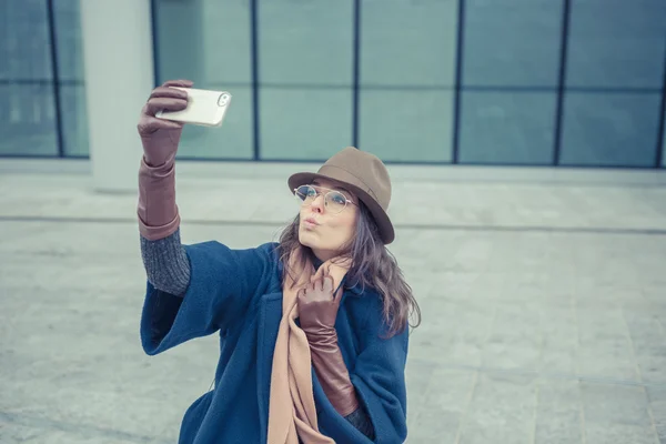 Bella giovane bruna che si fa un selfie per le strade della città — Foto Stock