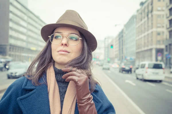 Krásná mladá brunetka pózuje v ulicích města — Stock fotografie