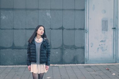 Genç güzel Çinli kız şehir sokaklarını poz