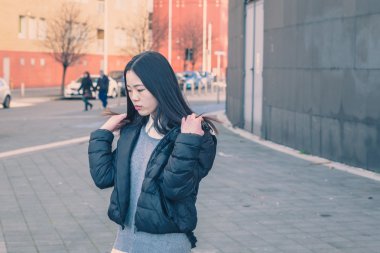 Genç güzel Çinli kız şehir sokaklarını poz