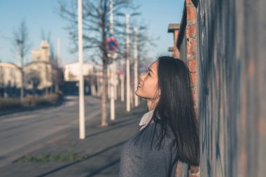 Genç güzel Çinli kız şehir sokaklarını poz