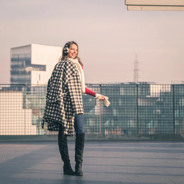 Krásná mladá brunetka pózuje v ulicích města — Stock fotografie