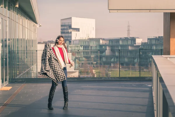 Krásná mladá brunetka pózuje v ulicích města — Stock fotografie