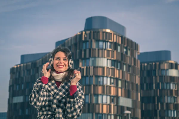 Krásná mladá brunetka pózuje v ulicích města — Stock fotografie