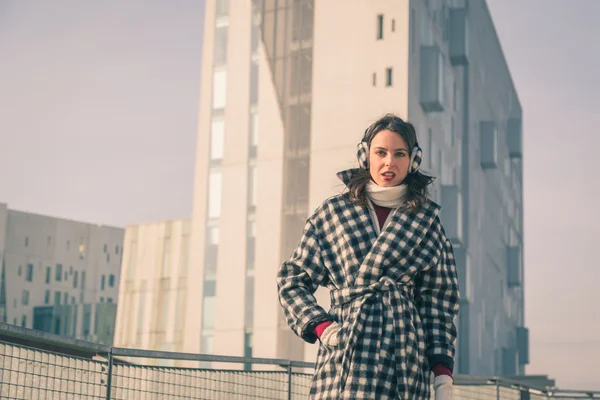 Krásná mladá brunetka pózuje v ulicích města — Stock fotografie