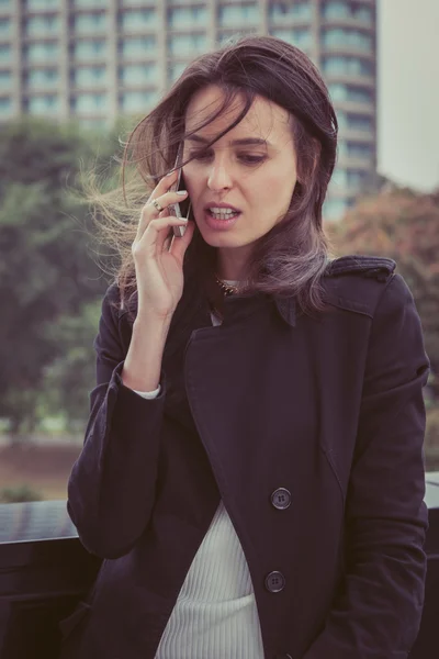 Jolie fille parlant au téléphone dans les rues de la ville — Photo