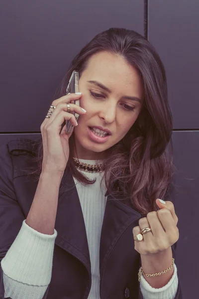 Красивая девушка разговаривает по телефону на улицах города — стоковое фото