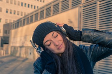 Güzel genç kadın şehir sokaklarda müzik dinlemek