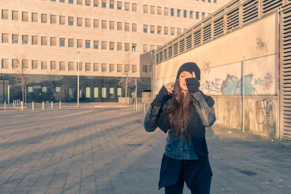 Krásná mladá žena pózuje v ulicích města — Stock fotografie