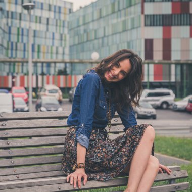 Güzel kız sokakta bir bankta oturmuş