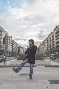 Genç yakışıklı sakallı adam şehir sokaklarını poz