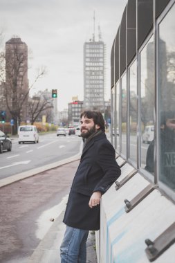 Genç yakışıklı sakallı adam şehir sokaklarını poz