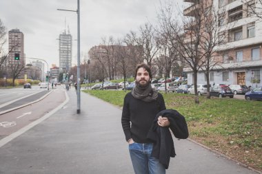 Genç yakışıklı sakallı adam şehir sokaklarını poz