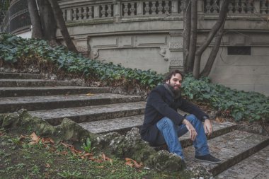 Genç yakışıklı sakallı adam şehir sokaklarını poz