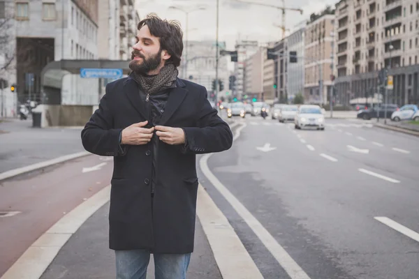 Молодой красивый бородатый мужчина позирует на улицах города — стоковое фото