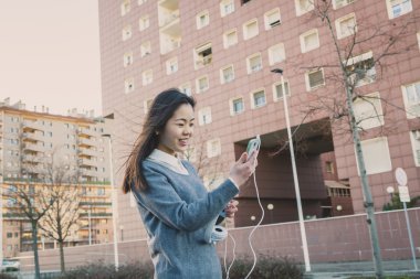 Genç güzel Çinli kız şehir sokaklarını poz