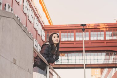 Genç güzel Çinli kız şehir sokaklarını poz