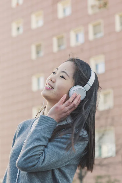 Mladá krásná čínská dívka se sluchátky — Stock fotografie