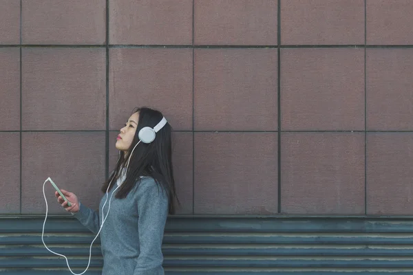 Young beautiful Chinese girl with headphones — Stock Photo, Image