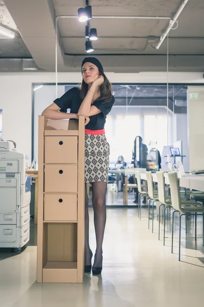 Krásná mladá brunetka pózuje v kanceláři — Stock fotografie