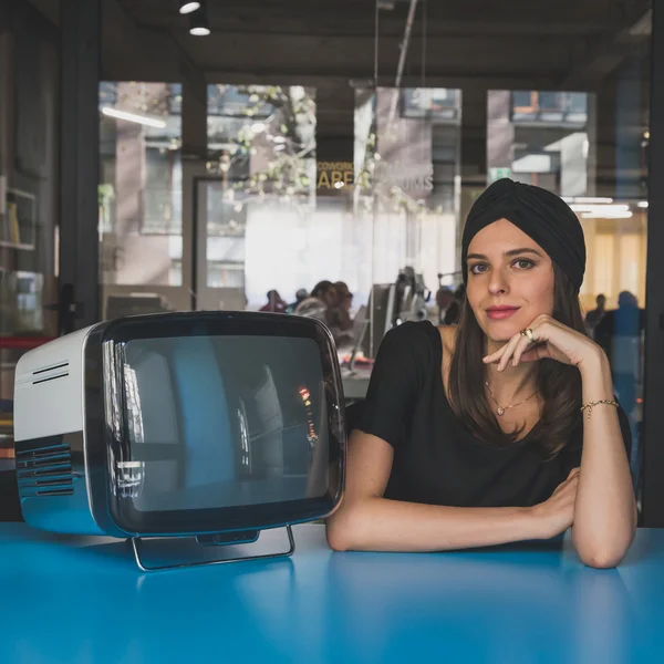 Beautiful young brunette posing beside a vintage tv — Stock Photo, Image